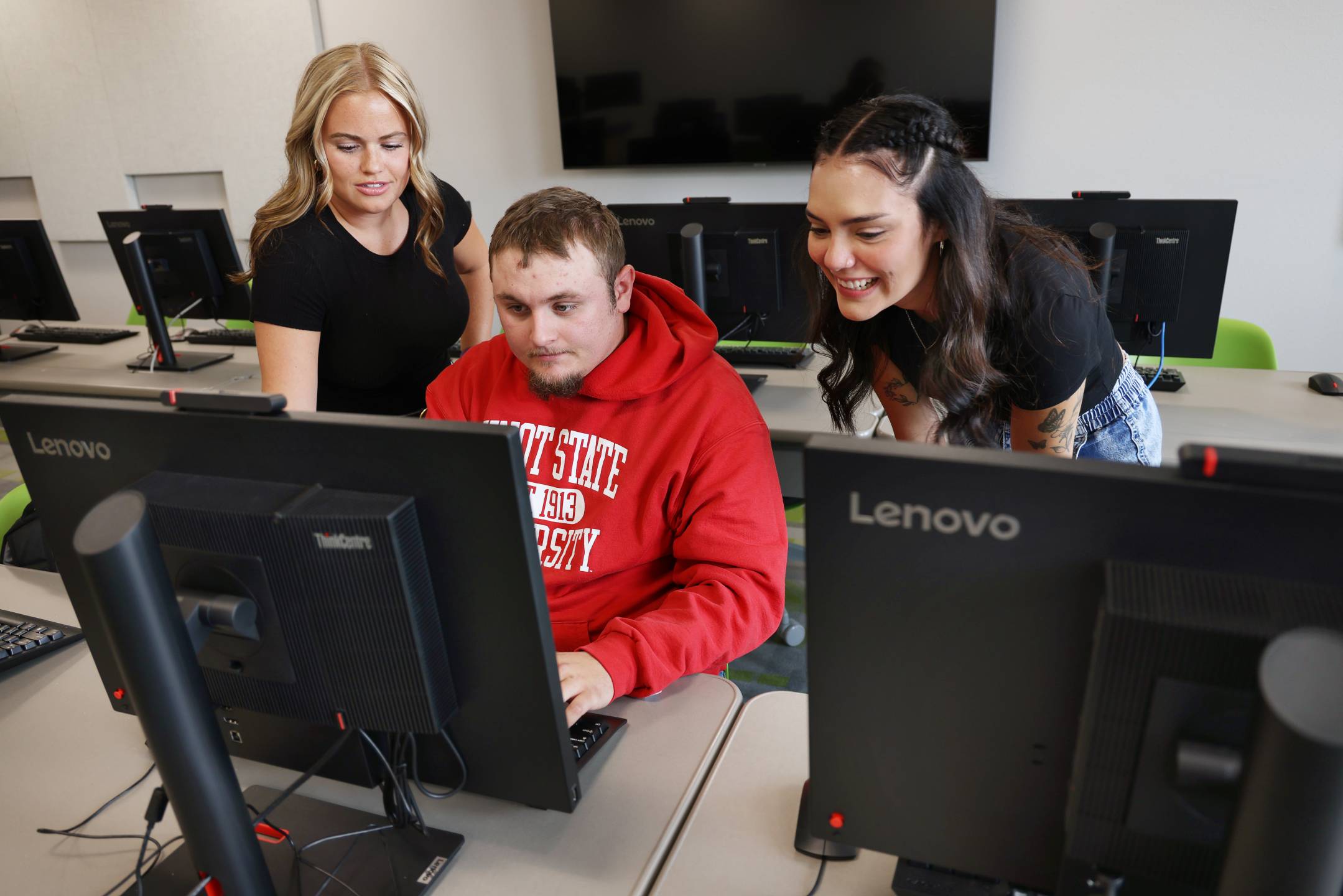 3 Minot State University students working together in a computer lab.