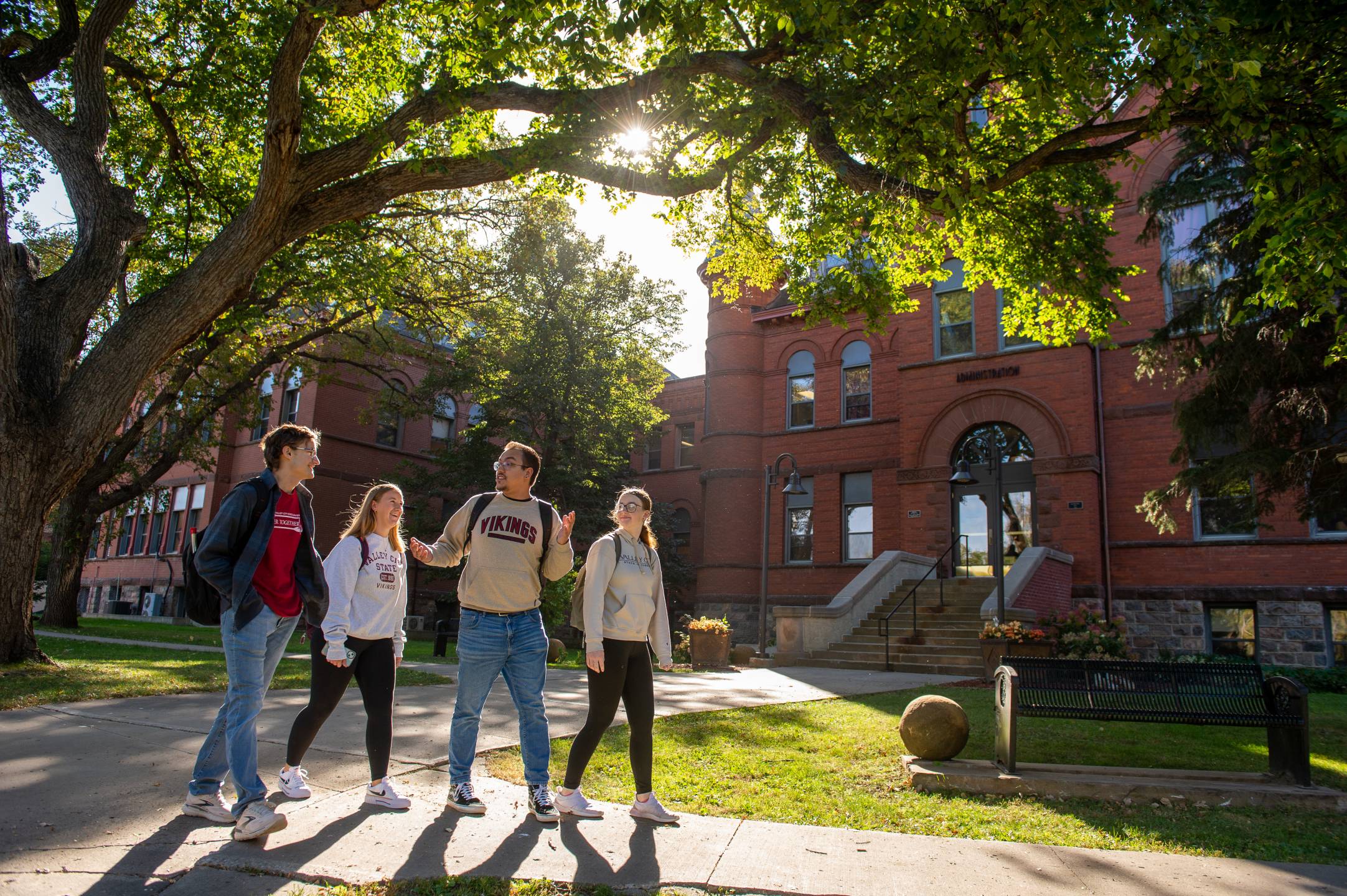 4 college students walking on Valley City State University campus.