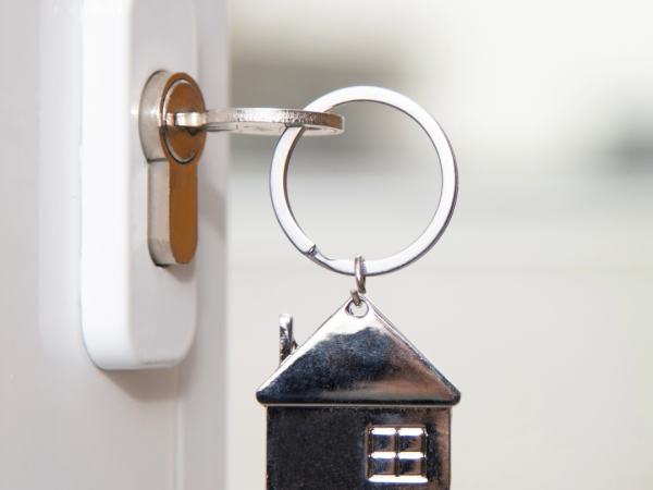 Key with a house keychain in a door lock.