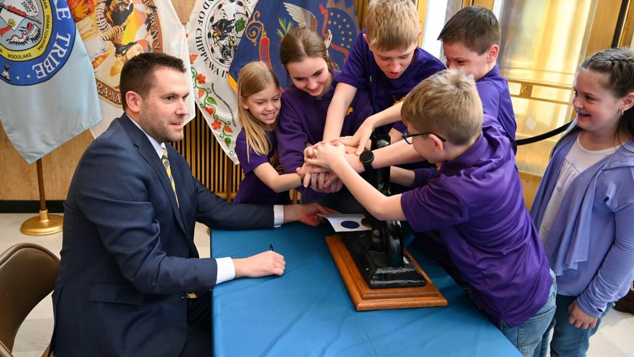 Kids helping Secretary apply the Great Seal